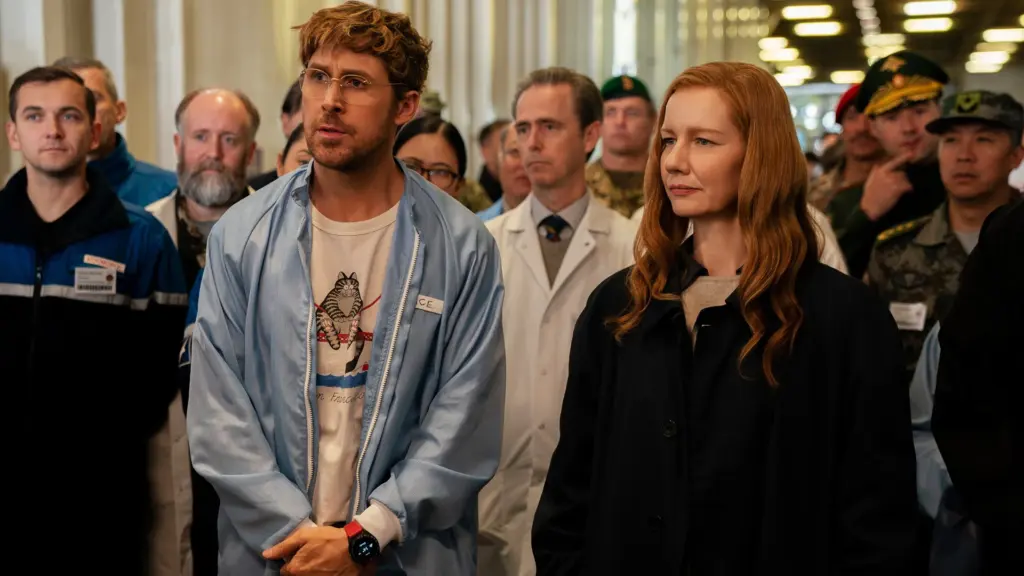 Two people stand in the foreground—a man with glasses in a light blue jacket and a red-haired woman in a dark coat—surrounded by a crowded hallway of professionals and soldiers behind them.